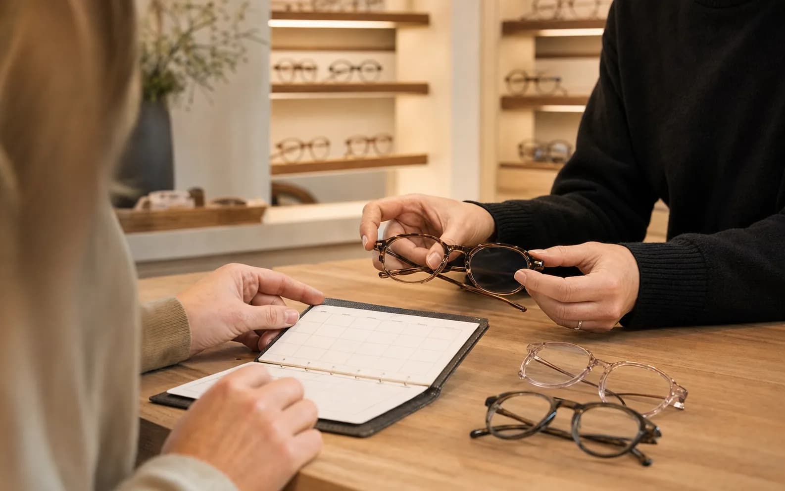 Anonyme Beratungssituation mit Brille und Terminplanung in einem Optikfachgeschäft